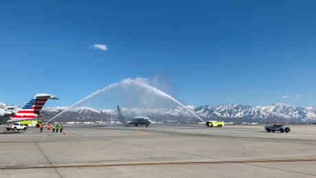 The jet carrying Hadfield's remains passes beneath a fire hose arch.