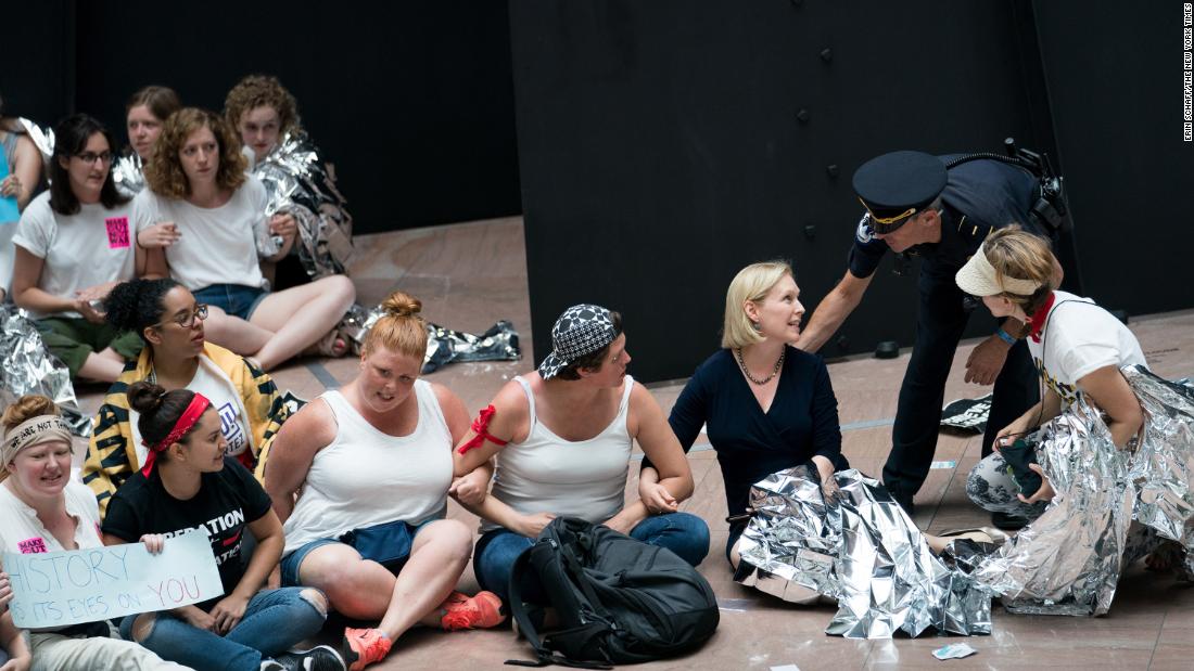 A Capitol Hill police officer speaks with Gillibrand, who had joined demonstrators at a Senate building in Washington in June 2018.