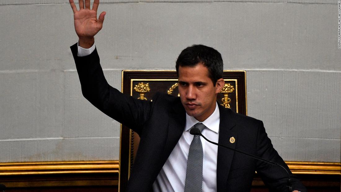 enezuelan opposition leader and self-proclaimed interim president Juan Guaido raises his hand during a session of the National Assembly in Caracas on March 26, 2019. - Guaido said the presence of Russian troops violates the Venezuelan constitution. Russian planes landed at an airport outside Caracas on the weekend reportedly containing around 100 soldiers and 35 tons of military equipment. (Photo by Federico PARRA / AFP)        (Photo credit should read FEDERICO PARRA/AFP/Getty Images)