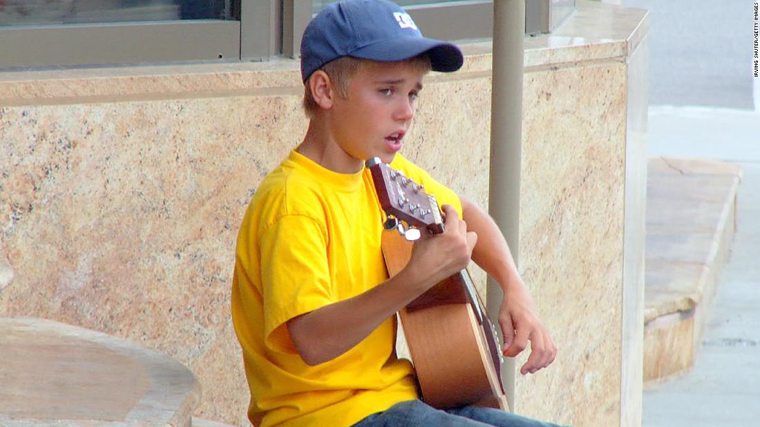 Bieber, 13, performs on the street in Stratford, Ontario, in August 2007. His mom posted videos of him singing on YouTube, and it soon caught the eye of record executive Scooter Braun.