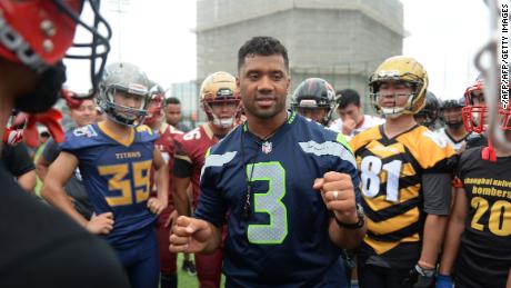 Quarterback Russell Wilson (C) takes part in a training session at a football camp in Shanghai in 2018.