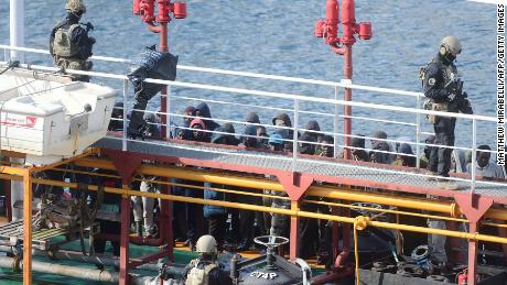 Maltese army forces and migrants pictured on board the hijacked tanker in Valletta.