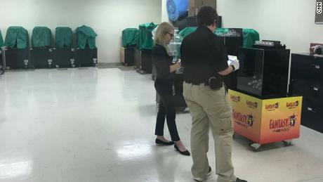 Lottery security agents check a Florida state lottery machine.