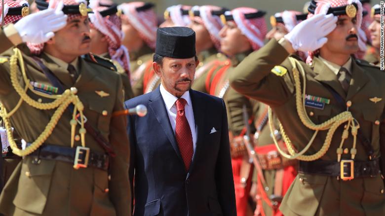 The Sultan of Brunei Hassanal Bolkiah (C) reviews the honor guard at the Royal Palace in Amman, on October 4.