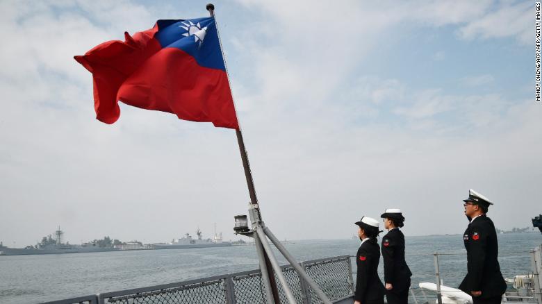 Taiwanese sailors salute the island&#39;s flag on the deck of the Panshih supply ship after taking part in live fire drills, at the Tsoying naval base in Kaohsiung on January 31, 2018.
