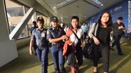 Philippine journalist Maria Ressa is escorted by police after an arrest warrant was served, shortly after arriving at the Ninoy Aquino International Airport in Manila.