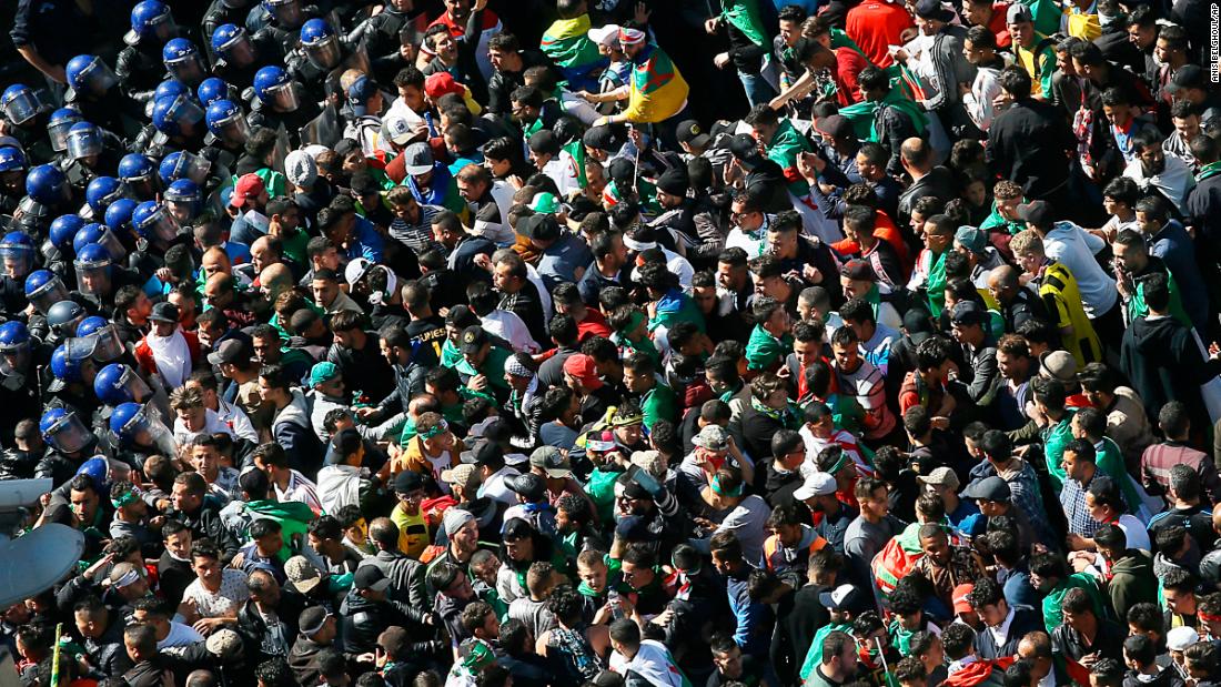 Police officers watch demonstrators during a protest in Algiers, Algeria, March 29, 2019. Algerians taking to the streets for their sixth straight Friday of protests aren&#39;t just angry at their ailing president, they want to bring down the entire political system that has sustained him. (AP Photo/Anis Belghoul)