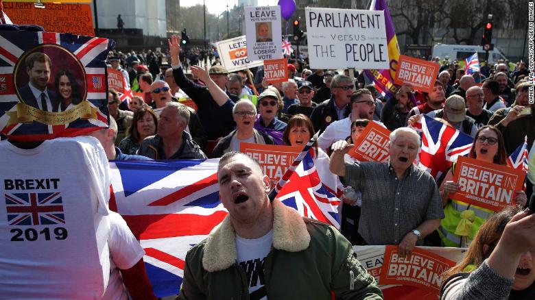 Pro-Brexit demonstrators carry placards and Union flags as they gather in Parliament Square in central London on March 29, 2019. 