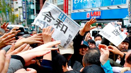 People reach for a copy of extra edition of the Sankei Shimbun newspaper reporting the name of new era.