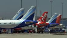 This photograph taken on March 8, 2018 shows an airplane of Air Asia, the low-cost airline headquartered in Malaysia, parked with other airliners at Kempe Gowda International Airport in Bangalore. - Shares of budget carrier AirAsia fell to a six-month low on May 30 after Indian authorities raided the airline&#39;s local offices and accused its boss Tony Fernandes of illegally obtaining operating licences. (Photo by Manjunath KIRAN / AFP)        (Photo credit should read MANJUNATH KIRAN/AFP/Getty Images)