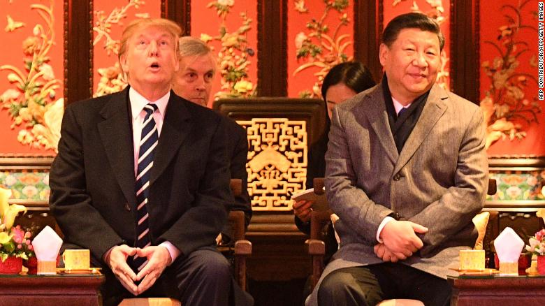 US President Donald Trump  looks up as he sits beside China&#39;s President Xi Jinping during a tour of the Forbidden City in Beijing on November 8, 2017. 