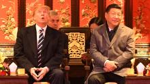 US President Donald Trump  looks up as he sits beside China&#39;s President Xi Jinping during a tour of the Forbidden City in Beijing on November 8, 2017. 