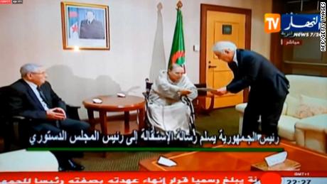 A TV grab from Ennahar TV shows Abdelaziz Bouteflika, center, hand in his resignation letter to the Constitutional Council in Algiers.