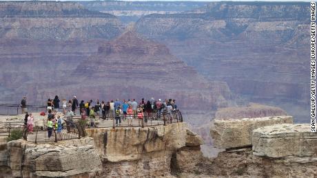 GRAND CANYON NATIONAL PARK, AR - JULY 14:  Visitors stand at the Grand Canyon South Rim on July 14, 2014 at Grand Canyon National Park, Arizona. The Grand Canyon is among the state's biggest tourist destinations.  (Photo by Sean Gallup/Getty Images)