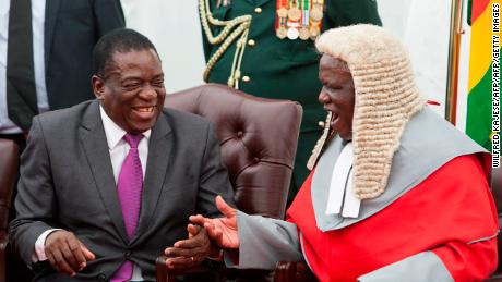 Zimbabwe&#39;s President Emmerson Mnangagwa, left, shakes hands with the country&#39;s chief justice Luke Malaba.