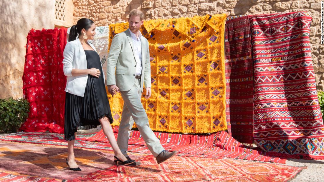 Meghan and Harry walk past tapestries during a visit to Rabat, Morocco, in February 2019.