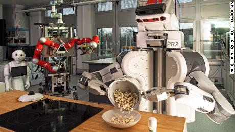 A robot pours popcorn from a cooking pot into a bowl on March 8, 2017 at the Institute for Artificial Intelligence (AI) of the university of Bremen, northwestern Germany.
