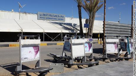 Luggage trolleys lie in front of the gate of the Mitiga airport after it was attacked Monday.