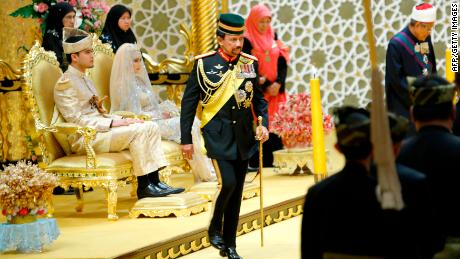 Brunei&#39;s Sultan Hassanal Bolkiah (center) returns after blessing to the royal couple Princess Hajah Hafizah Sururul Bolkiah and her groom Pengiran Haji Muhammad Ruzaini (left) at the end of the sitting-in-state on royal dais ceremony at Istana Nurul Iman in Brunei&#39;s capital Bandar Seri Begawan on September 23, 2012. 