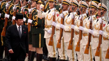 Brunei&#39;s Sultan Hassanal Bolkiah reviews a Chinese honor guard during a welcome ceremony at the Great Hall of the People in Beijing in September 2017.