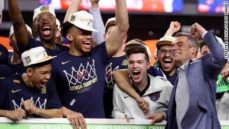 Virginia Cavaliers head coach Tony Bennett places his team&#39;s name as National Champion on the bracket after their 85-77 win over Texas Tech.