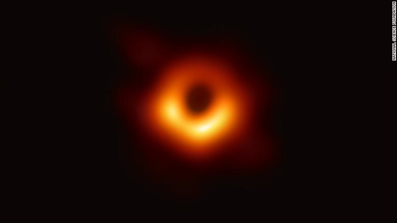 orange and black image of the supermassive black hole at center of Milky Way. the orange is the plasma ring around the black hole.