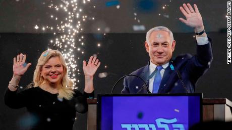 Israeli Prime Minister Benjamin Netanyahu, accompanied by his wife Sara, greets supporters.