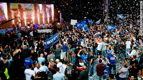 Likud supporters celebrate as Prime Minister Benjamin Netanyahu waves to them at its headquarters in Tel Aviv.