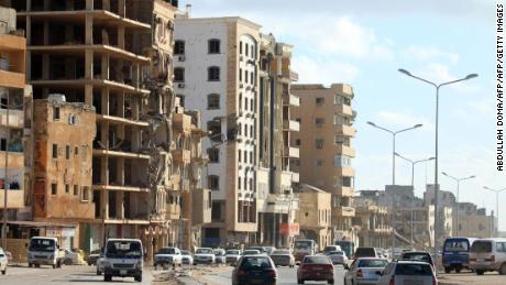 Cars drive past buildings, heavily damaged from previous clashes in Libya&#39;s eastern city of Benghazi on April 8, 2019. 