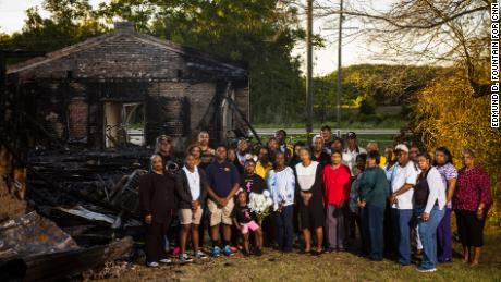 Members of the congregation of Greater Union Baptist Church stand for a portrait in front of the ruins of their former church.