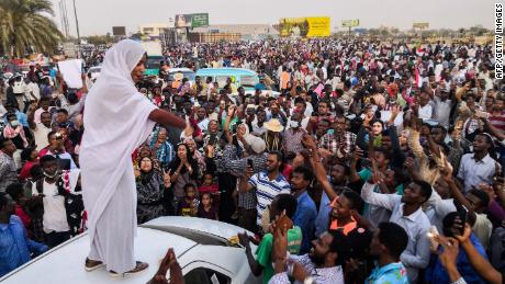 Alaa Salah, a Sudanese woman propelled to internet fame earlier this week after clips went viral of her leading powerful protest chants against President Omar al-Bashir, addresses protesters during a demonstration in front of the military headquarters in the capital Khartoum on April 10, 2019. - In the clips and photos, the elegant Salah stands atop a car wearing a long white headscarf and skirt as she sings and works the crowd, her golden full-moon earings reflecting light from the fading sunset and a sea of camera phones surrounding her. Dubbed online as &quot;Kandaka&quot;, or Nubian queen, she has become a symbol of the protests which she says have traditionally had a female backbone in Sudan. 