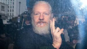 LONDON, ENGLAND - APRIL 11: Julian Assange gestures to the media from a police vehicle on his arrival at Westminster Magistrates court on April 11, 2019 in London, England.  After weeks of speculation Wikileaks founder Julian Assange was arrested by Scotland Yard Police Officers inside the Ecuadorian Embassy in Central London this morning. Ecuador's President, Lenin Moreno, withdrew Assange's Asylum after seven years citing repeated violations to international conventions. (Photo by Jack Taylor/Getty Images) 