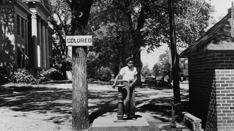 A young boy drinks from the &quot;colored&quot; water fountain on the county courthouse lawn in Halifax, North Carolina, in 1938. 