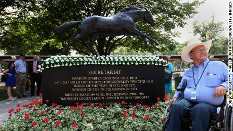 Ron Turcotte poses next to a statue of Secretariat at Belmont Park, USA. 