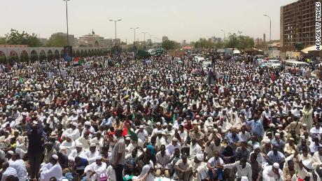 Sudanese protesters gather near the military headquarters in Khartoum as they continue to rally demanding a civilian body to lead the transition to democracy one day after a military council took control of the country, on April 12, 2019.