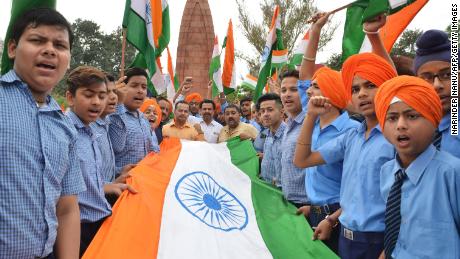 Indian school students hold the national flag in honor of the Jallianwala Bagh massacre, on the eve of the anniversary.