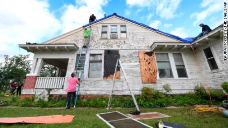 Volunteers cover the roof of a Franklin, Texas, home with a tarp on Saturday, April 13, 2019, after a powerful storm caused damage.