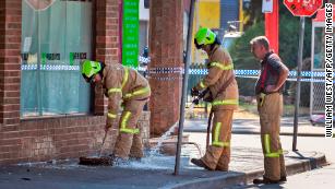 Firefighters wash away bloodstains at the scene of a deadly shooting in Melbourne, Australia.