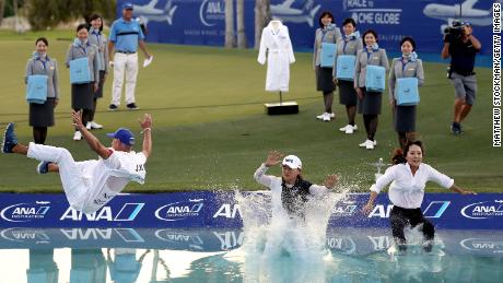 Ko Jin-young, her caddie David Brooker and her agent Choi Soo-jin leap into Poppie&#39;s Pond after her win in 2019.