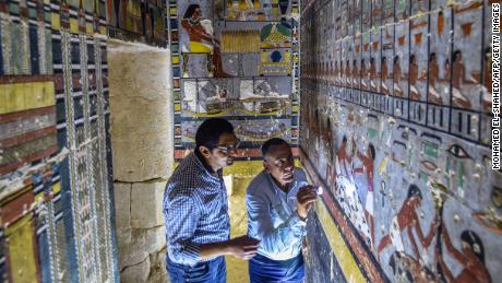 Mohamed Mujahid (L), head of the Egyptian mission which discovered the tomb of the ancient Egyptian nobleman &quot;Khewi&quot; dating back to the 5th dynasty (24942345 BC), inspects the tomb&#39;s walls inside at the Saqqara necropolis, about 35 kilometres south of the capital Cairo on April 13, 2019. (Photo by Mohamed el-Shahed / AFP)        (Photo credit should read MOHAMED EL-SHAHED/AFP/Getty Images)