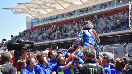 Young pretender Alex Rins held aloft by his team after his victory.