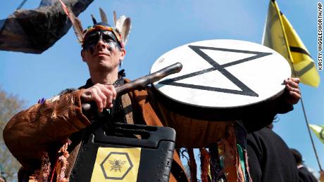 A demonstrator bangs a drum during a climate protest in London&#39;s Parliament Square.