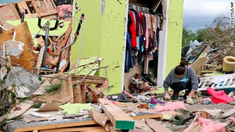 Woman in Mississippi searches for belongings in her storm-damaged house.