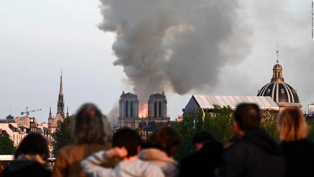 Passers-by watch the cathedral burn. &quot;It&#39;s tremendously sad to see this happening to such an iconic monument,&quot; bystander Cameron Mitchell &lt;a href=&quot;https://www.cnn.com/world/live-news/notre-dame-fire/h_f0e87d76f5c736f2e79dffdf7e363b01&quot; target=&quot;_blank&quot;&gt;told CNN.&lt;/a&gt;