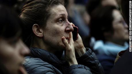 A woman reacts as she watches the flames engulf the roof of the  Notre-Dame Cathedral in Paris on April 15, 2019. - A huge fire swept through the roof of the famed Notre-Dame Cathedral in central Paris on April 15, 2019, sending flames and huge clouds of grey smoke billowing into the sky. The flames and smoke plumed from the spire and roof of the gothic cathedral, visited by millions of people a year. A spokesman for the cathedral told AFP that the wooden structure supporting the roof was being gutted by the blaze. (Photo by Geoffroy VAN DER HASSELT / AFP)        (Photo credit should read GEOFFROY VAN DER HASSELT/AFP/Getty Images)