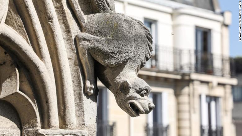 A distressed gargoyle adorns the exterior of Notre Dame Cathedral.