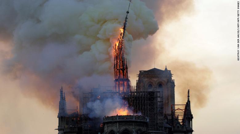 The steeple of the landmark Notre Dame cathedral collapses as the cathedral is engulfed in flames in central Paris.