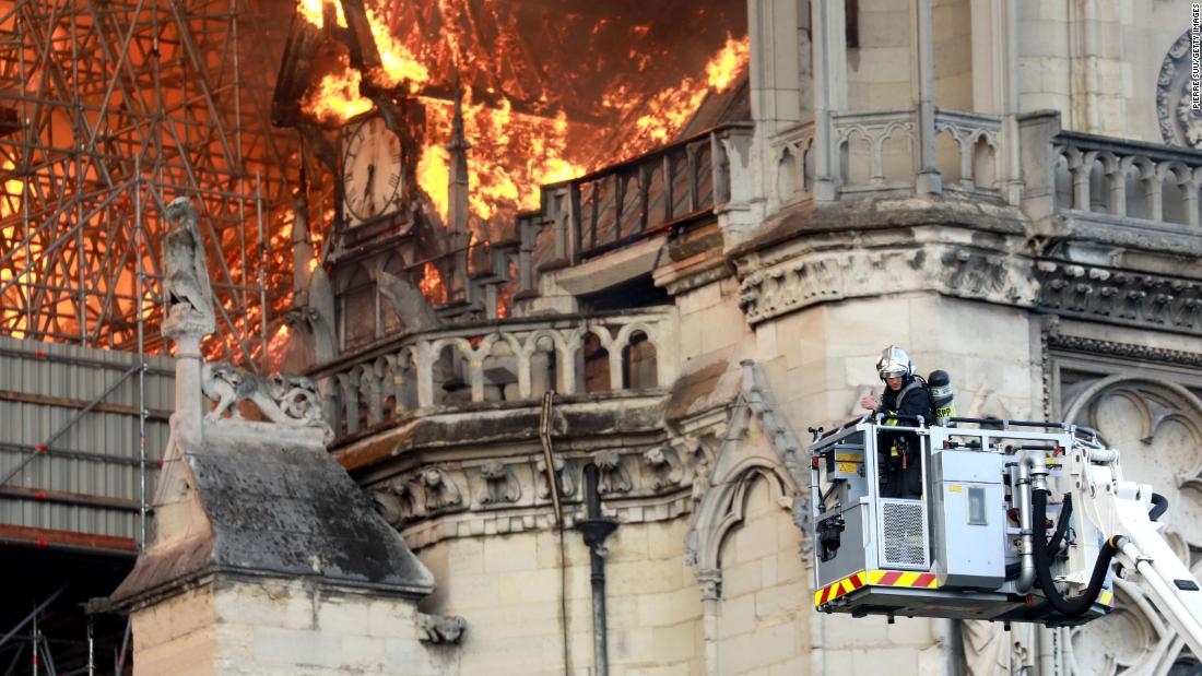 A firefighter gets closer to the flames.