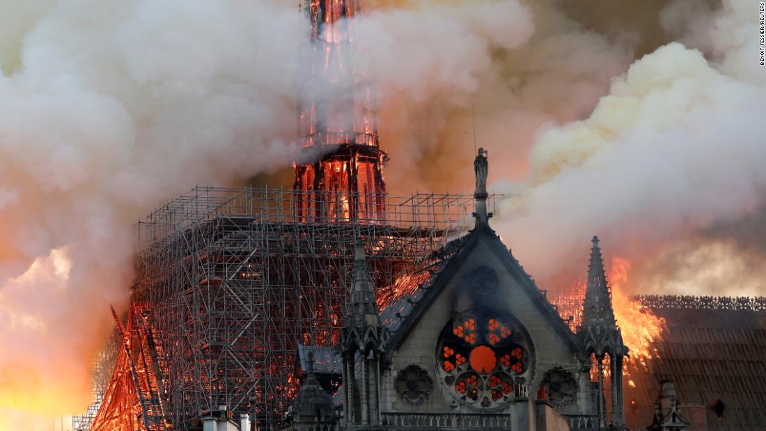 Smoke billows from the cathedral&#39;s roof and spire during the fire.