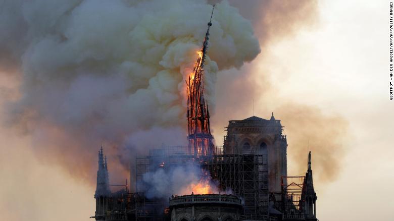 The steeple of the landmark Notre-Dame Cathedral collapses as the cathedral is engulfed in flames in central Paris on April 15, 2019. - A huge fire swept through the roof of the famed Notre-Dame Cathedral in central Paris on April 15, 2019, sending flames and huge clouds of grey smoke billowing into the sky. The flames and smoke plumed from the spire and roof of the gothic cathedral, visited by millions of people a year. A spokesman for the cathedral told AFP that the wooden structure supporting the roof was being gutted by the blaze. (Photo by Geoffroy VAN DER HASSELT / AFP)        (Photo credit should read GEOFFROY VAN DER HASSELT/AFP/Getty Images)